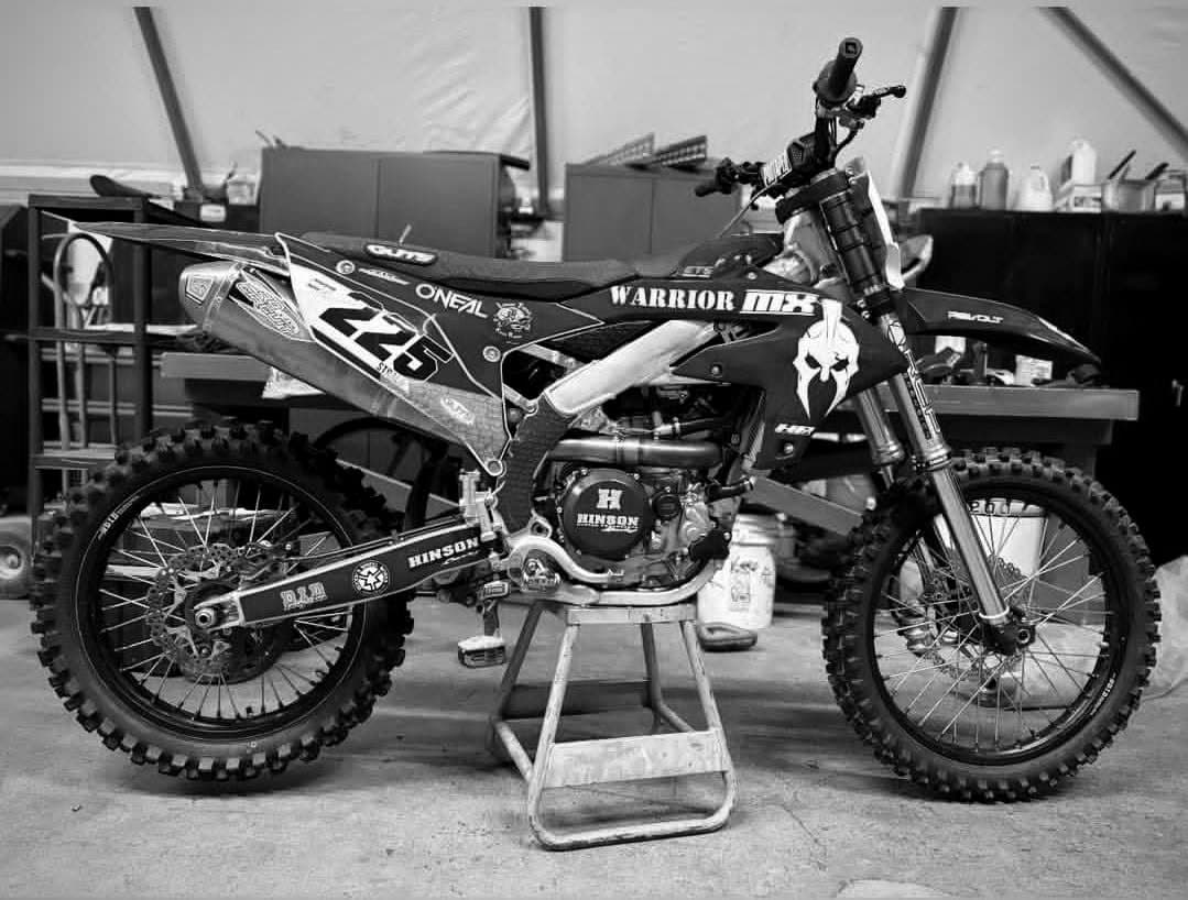 A Warrior MX race bike on a stand in the team shop